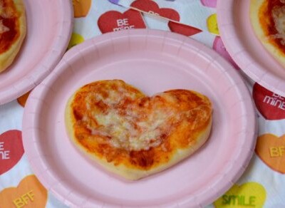 Looking for a fun Valentine's Day recipe to make with the kids? Check out these easy mini heart shape pizzas made with cookie cutters!