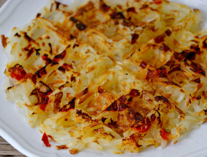Learn how to make hash browns in a waffle maker! Add in onions and red peppers for a delicious breakfast side dish.