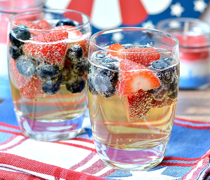 Sparkling juice in a cup with strawberries and blueberries