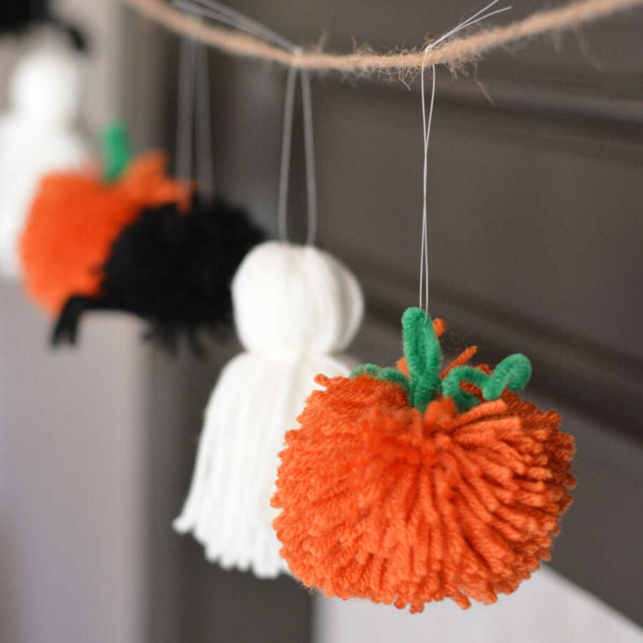 Halloween garland with yarn pumpkin, ghost, and spider on a mantle