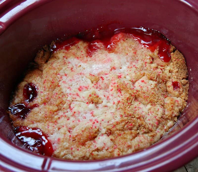 Cooked slow cooker cherry cobbler in red oval slow cooker