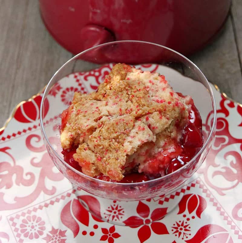 A scoop of slow cooker cherry cobbler in a clear dish