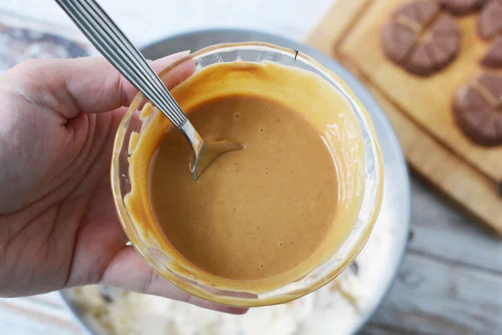 Melted peanut butter in a bowl with a spoon.