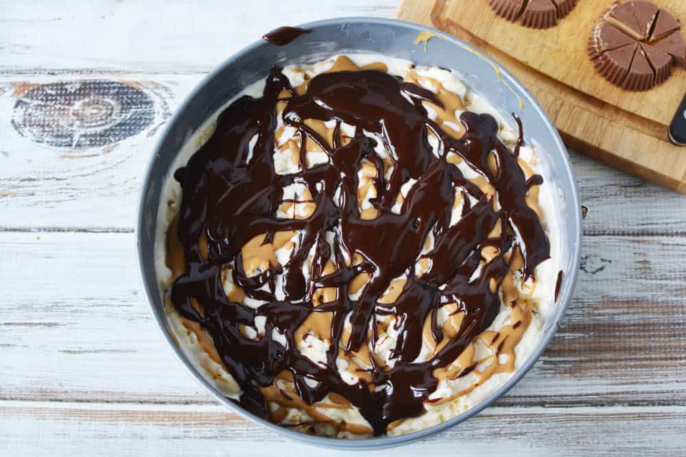 Ice cream in a cake pan topped with peanut butter and hot fudge
