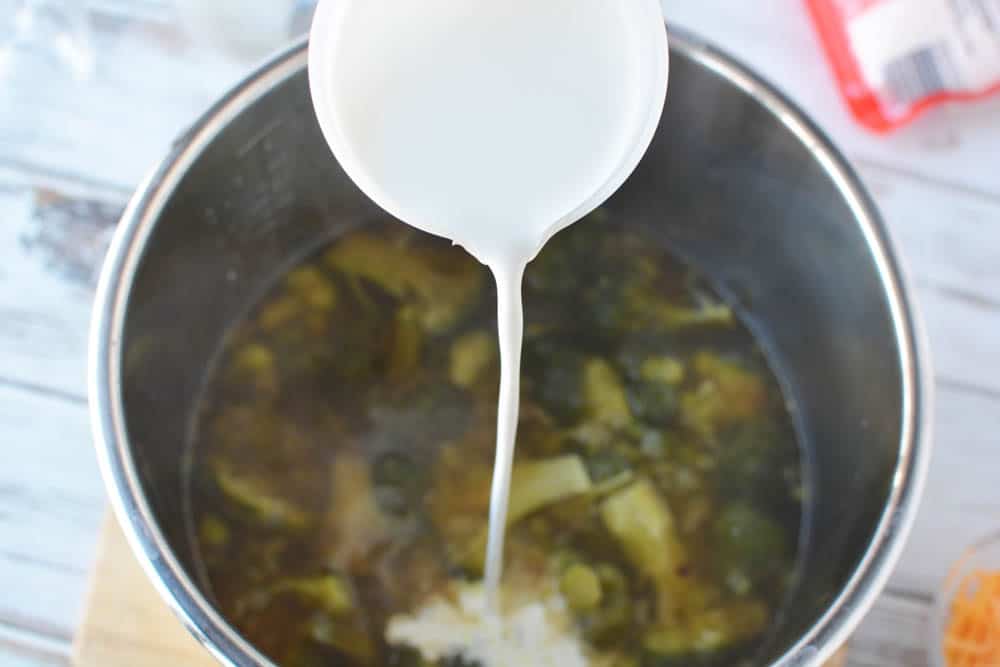 Cream being poured into Instant Pot for Instant Pot broccoli and cheese soup 