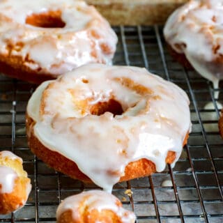 Glazed sour cream donuts on a cooling rack