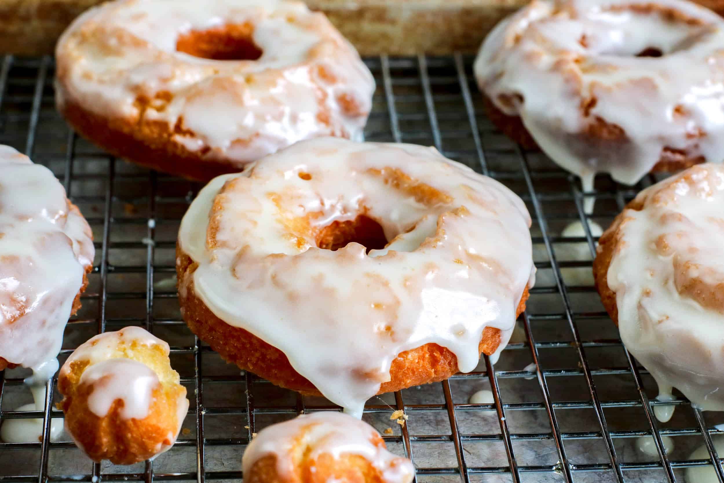Glazed sour cream donuts on a cooling rack