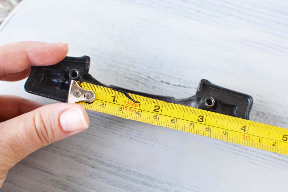 tape measure measuring the width of drawer handles