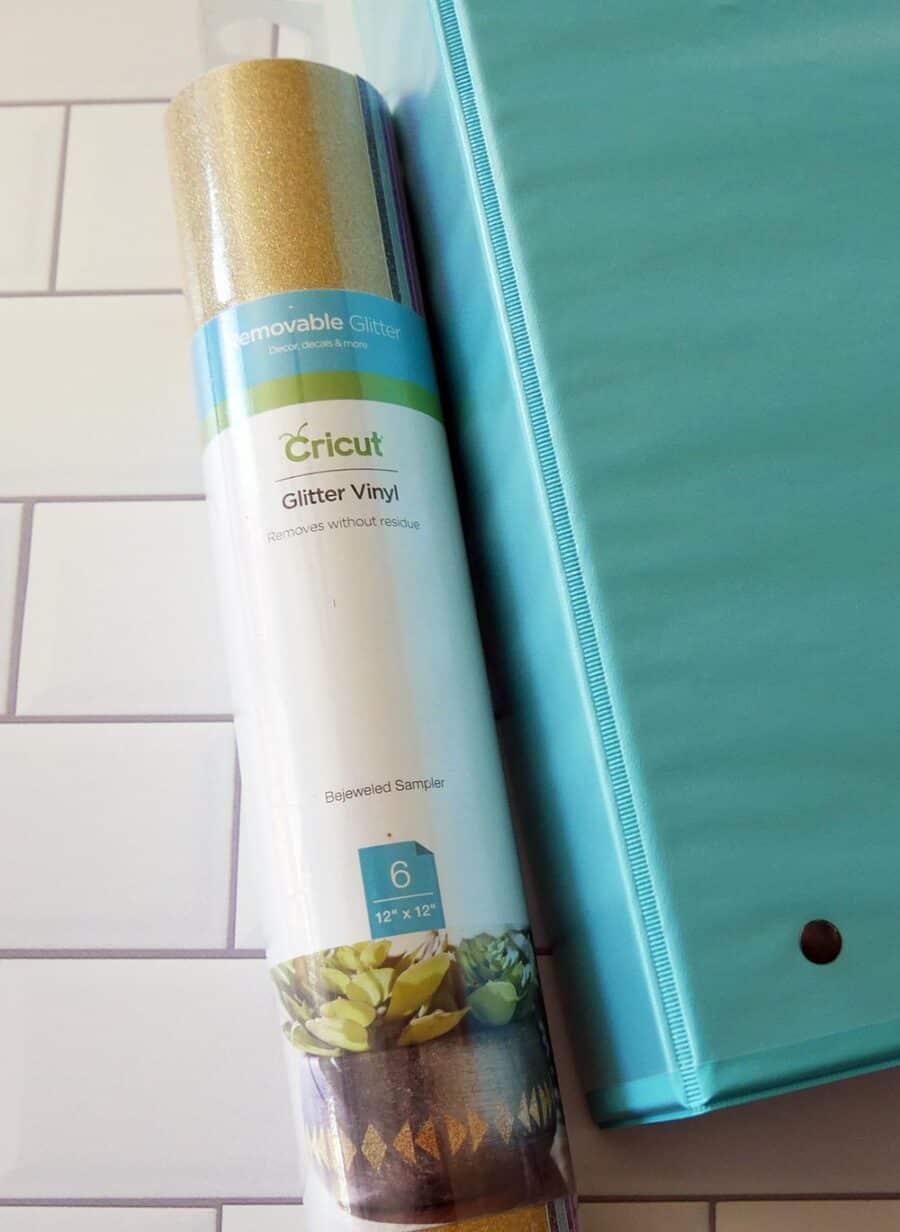 Roll of Cricut Removable Vinyl next to a binder