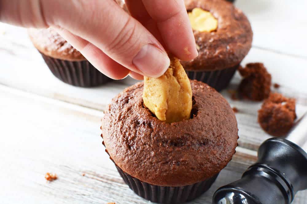 Filling a chocolate cupcake with the peanut butter filling