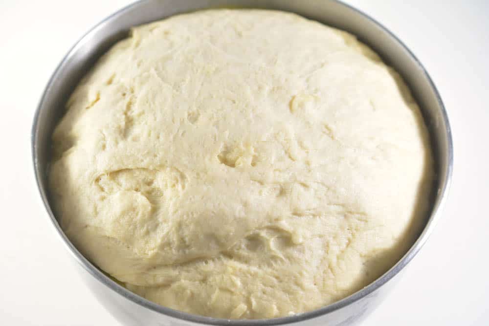 Risen bread dough in a mixing bowl