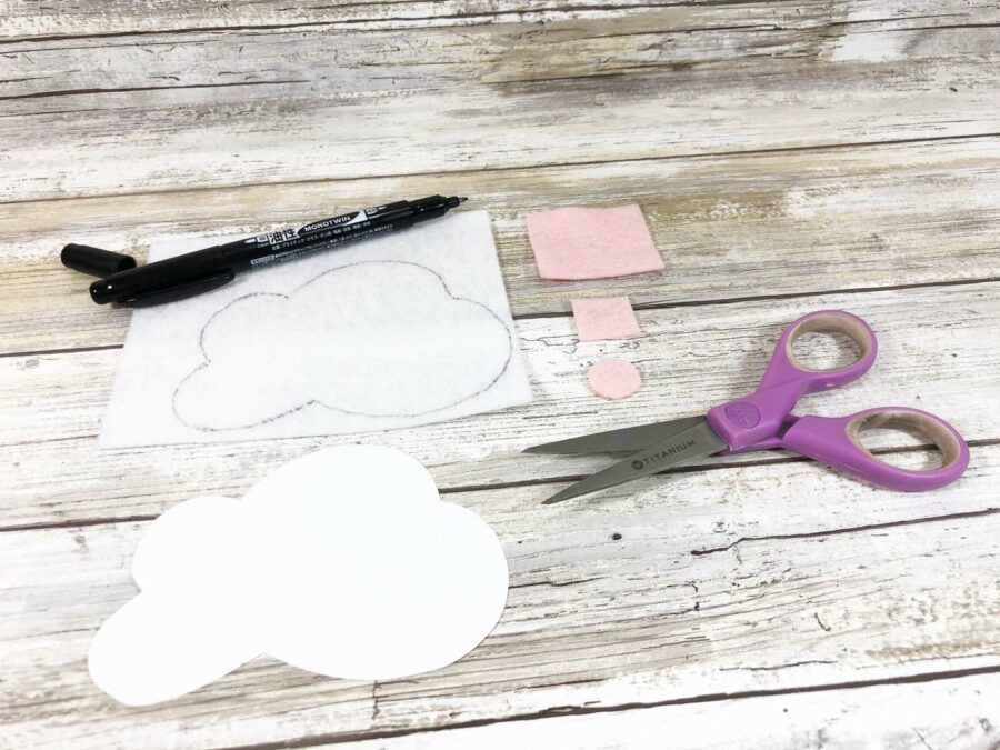 white felt clouds with pink felt scissors and a black marker