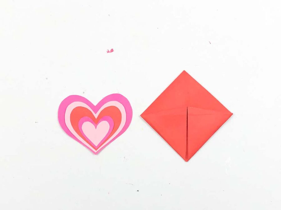 Pink and red hearts next to origami corner bookmark