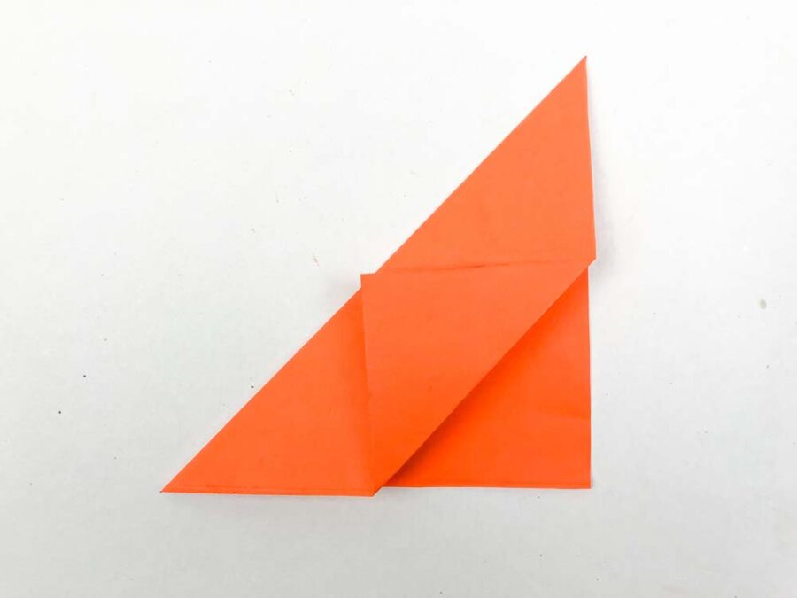 Orange paper folded in half and tip folded forward