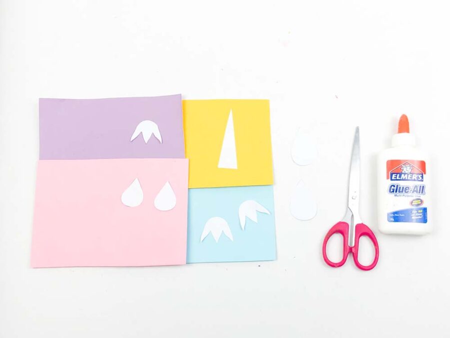 Unicorn template pieces on paper with scissors and glue