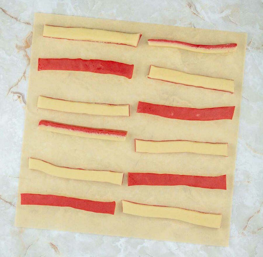 red and plain cookie dough cut into strips