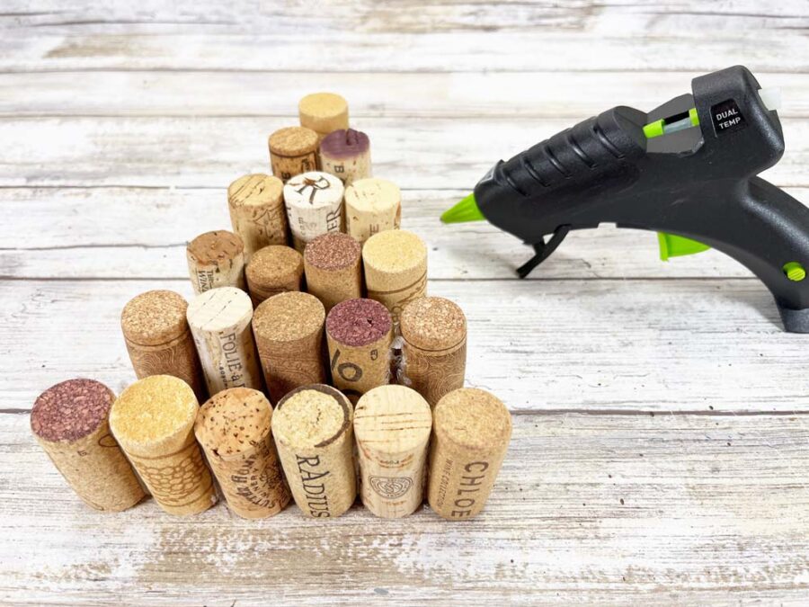 multiple wine corks in a triangle shape next to a glue gun