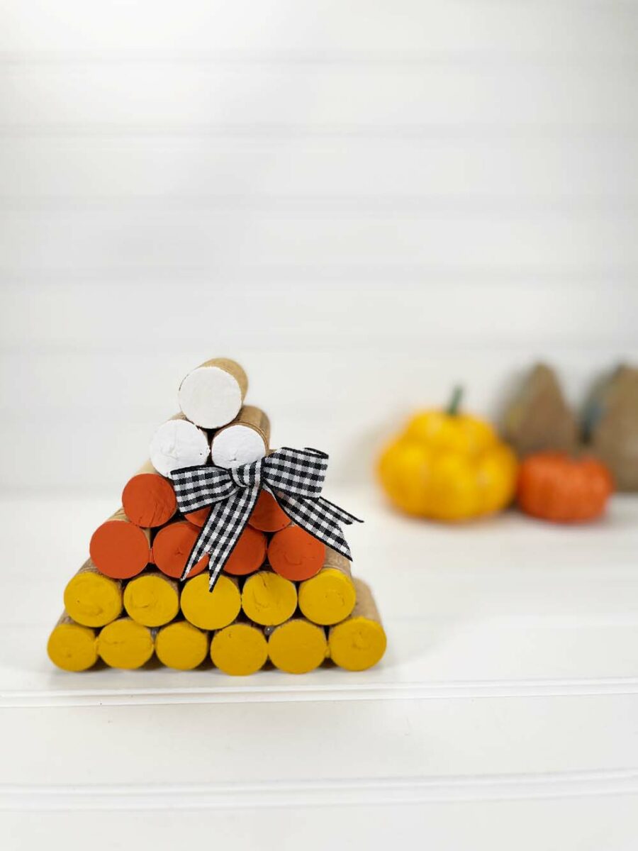 Zoomed out imagine of stacked wine corks painted yellow orange and yellow with bow in the middle 