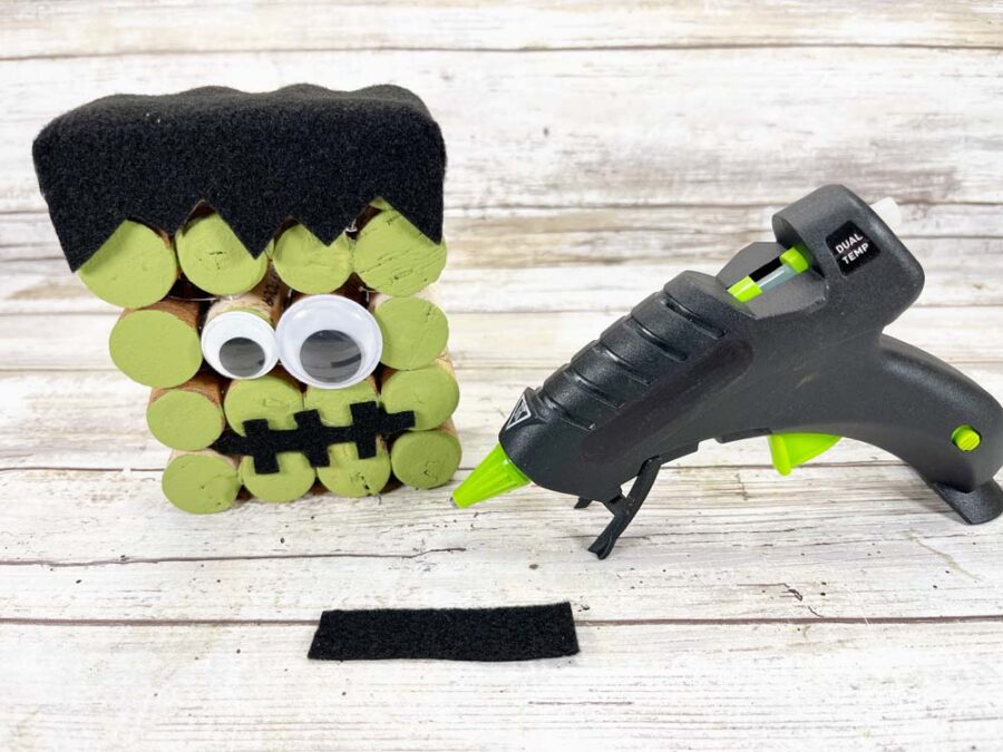 Frankenstein wine cork face with googly eyes and a glue gun