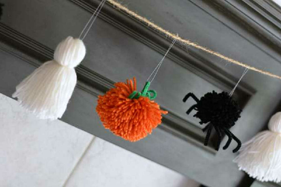 Ghost, pumpkin, and spider made with yarn and tied to twine.