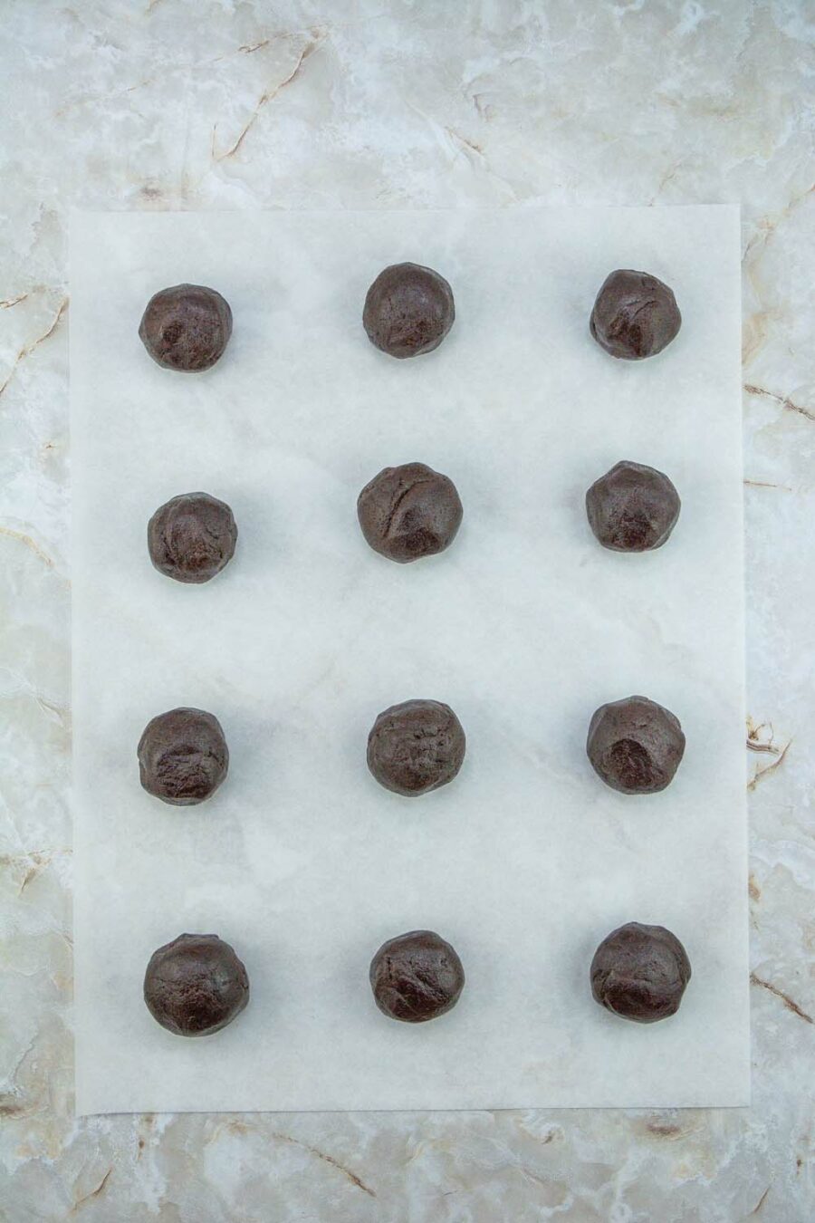 Chocolate Peppermint Cookie dough in balls on parchment paper