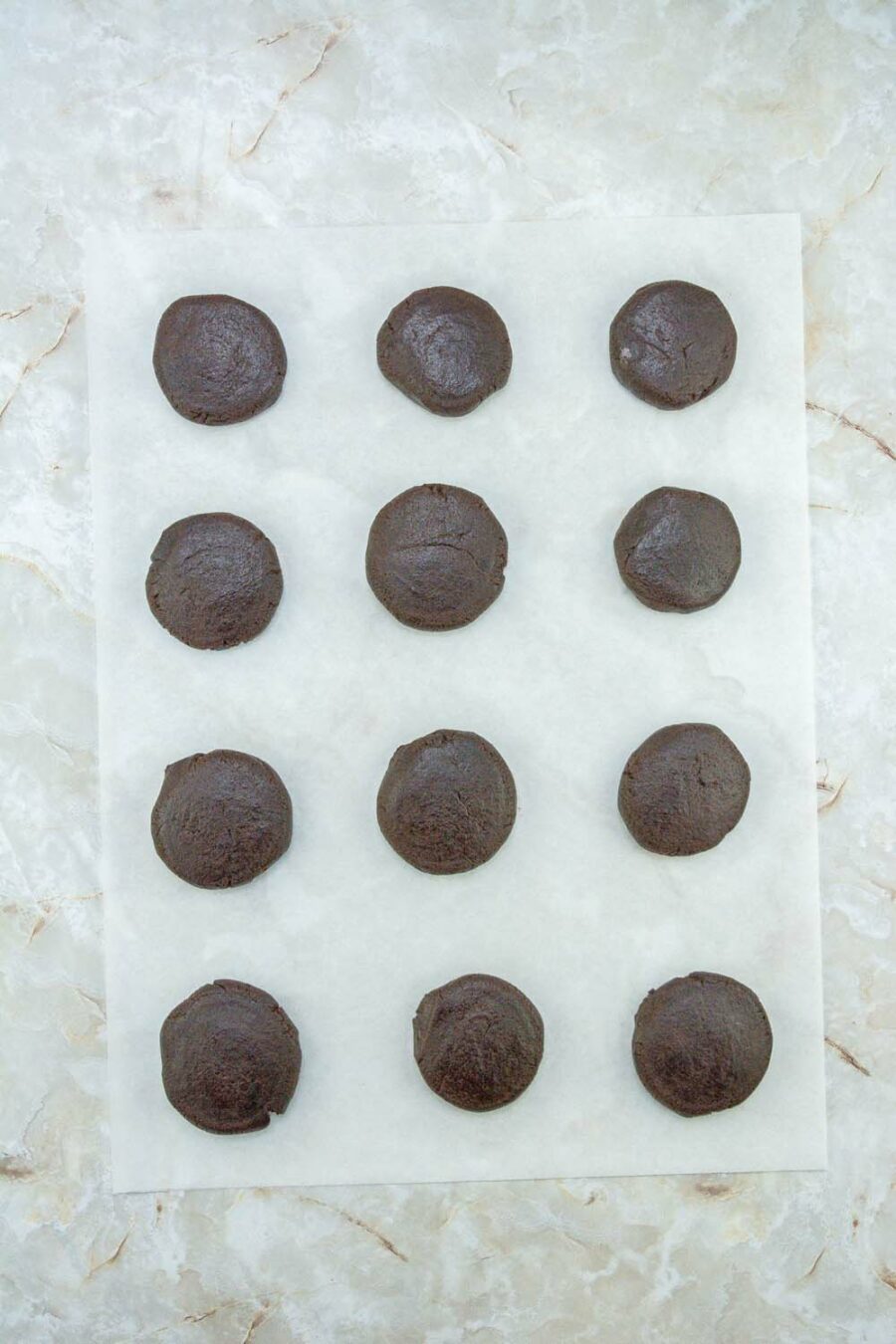 Chocolate peppermint cookie dough flattened on parchment paper